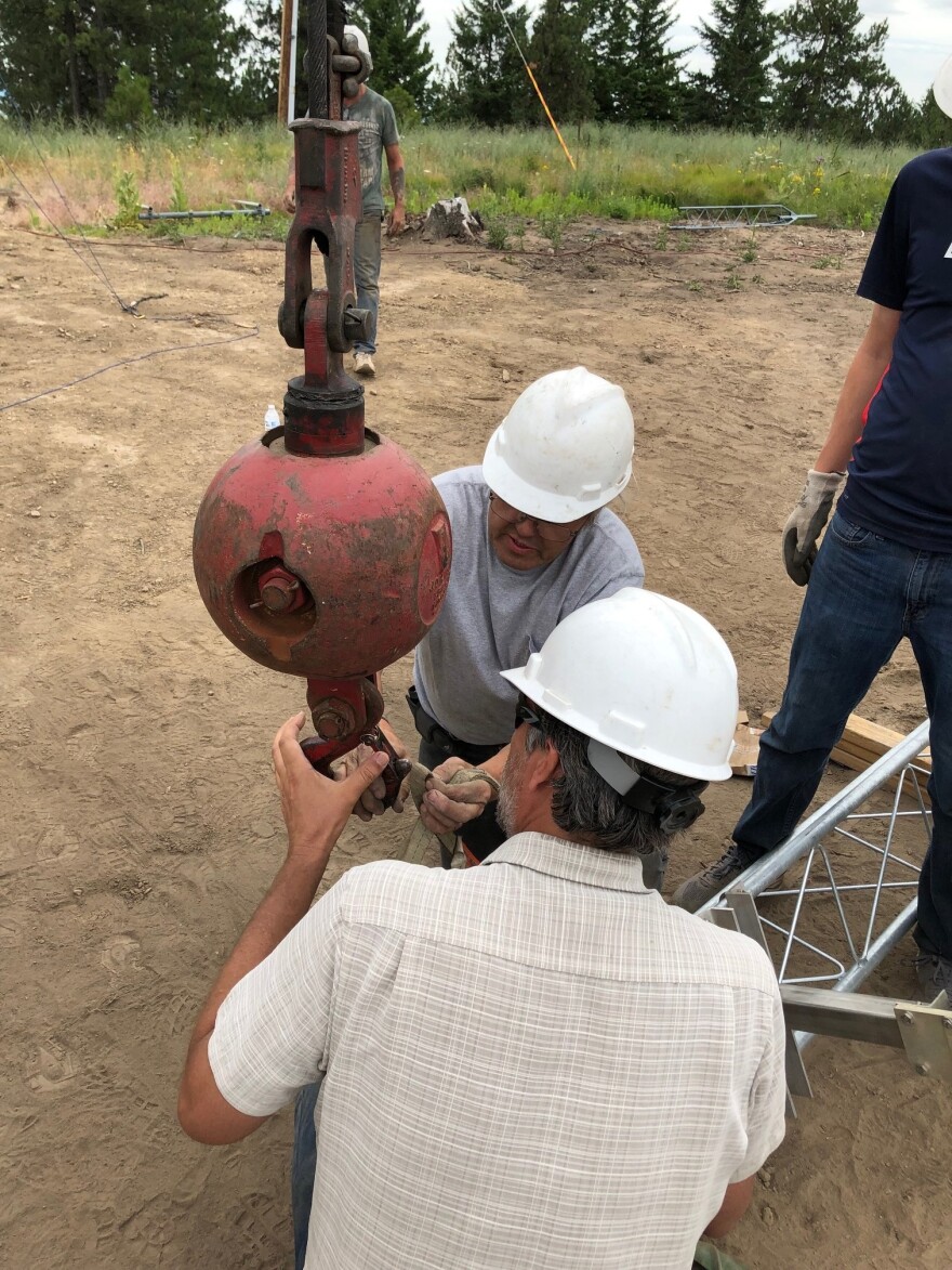 Two engineers holding a crane hook ready to lift the tower.