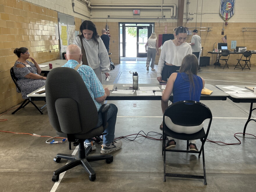 Two election judges greet voters at the Hibbing Precinct 1 polling location at the National Guard armory for the 2026 midterm primary on Aug. 11, 2026.