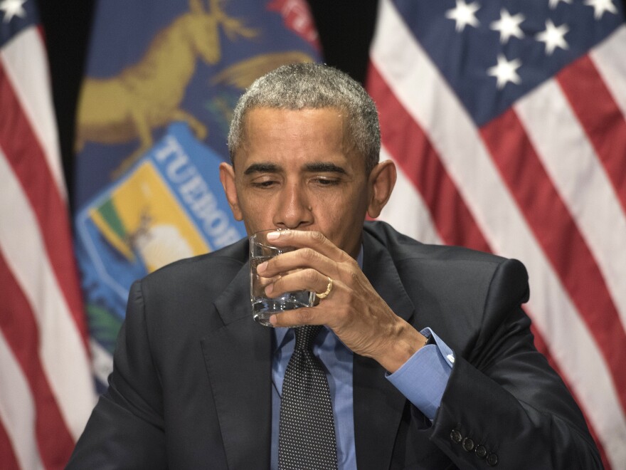 President Obama drinks a glass of filtered Flint water during a meeting with federal officials at the Food Bank of Eastern Michigan in Flint, Mich., on Wednesday.