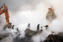 Firefighters make their way over the ruins of the World Trade Center through clouds of smoke at ground zero in New York.