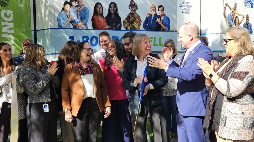 Roswell CEO Candace Johnson, third from right, shares a laugh with Congressman Tim Kennedy after unveiling the cancer center's new mobile screening van, pictured behind.