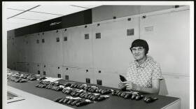 Roxie Laybourne stands behind the counter in the Birds Division with dozens of a single species of songbird laid out in rows.