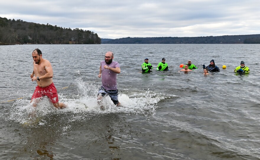 Andre Weeks and Alberto Mederios run out of the water after taking a plunge into Lake Wallenpaupack.