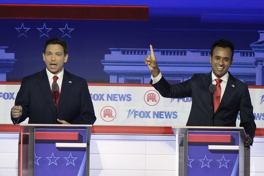 two men behind a podium, both in suits