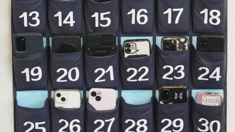 FILE - A phone holder hangs in a classroom in Utah.