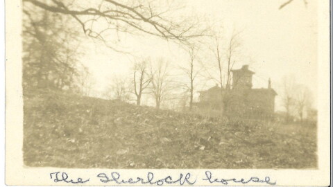 A sepia-toned photograph of a building from a distance.