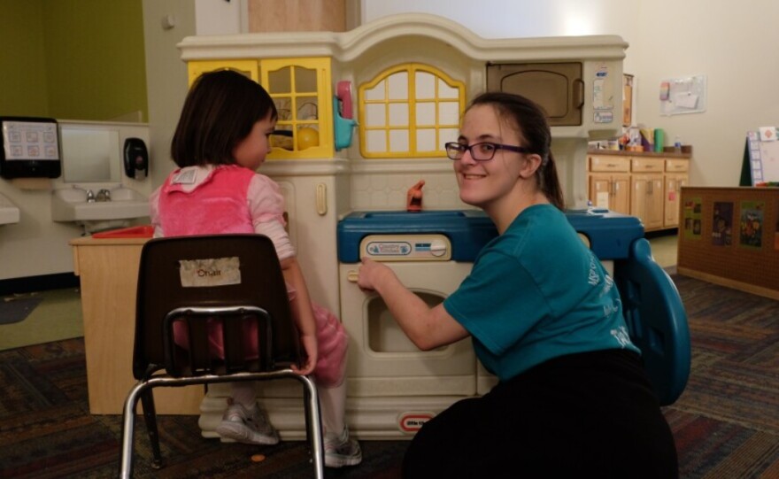 Maggie McCrumb plays with a child at a day care center while being assessed by a "vocational evaluator," in order to get help with job placement from New York state. Photo taken in 2017.