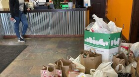 The Candied Yam staff standing next to bags of donations