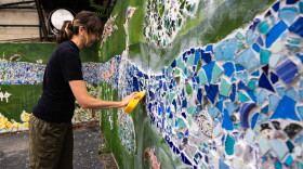 Whitesburg artist Lacy Hale works on a mural commemorating those who perished in the flood of 2022.