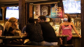 An employee at Little Woodrow's on West Sixth Street wears a mask on May 22. 