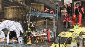 Rescuers evacuate injured people in Liege, Belgium, today, after a grenade and gun attack that killed at least three and injured dozens.