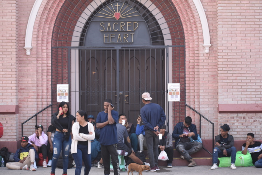 A group of migrants sit outside of Sacred Heart Church in El Paso, Texas on May 2, 2023. The church and the surrounding sidewalks have served as temporary sleeping quarters for hundreds of asylum seekers that have crossed into the Texas city.