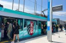 People board a streetcar with a KC Current-branded wrap