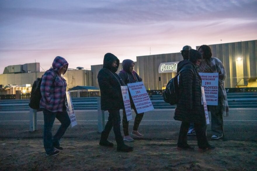 Striking employees carry picket signs near the JBS meatpacking plant Monday, March 16, 2026, in Greeley. Approximately 3,800 meatpackers are on strike, as of 5:30 a.m. Monday, after the United Food and Commercial Workers Local 7 bargaining committee voted to end an extension of an expired contract.