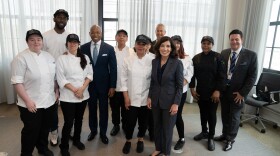 Gov. Kathy Hochul and New York City Mayor Eric Adams pose with restaurant workers who support allowing newly arrived asylum-seekers to get jobs.