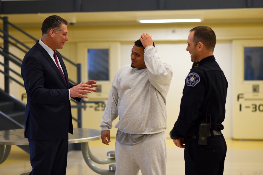 Middlesex County Sheriff Peter Koutoujian, inmate Eric Darden and Corrections Officer Stephen Hall talk in the unit's common area.