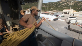 Seaman David Ndjongangbanen, assigned to the USS Bataan throws a mooring line as the ship pulls into Souda Bay, Crete. Jan. 20, 2024. Department of Defense