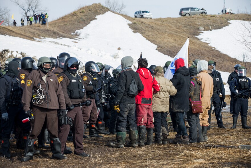 Protestors line up, arms linked, in peaceful protest as police enter the Oceti Sakowin camp on Thursday morning. All of the demonstrators were arrested.