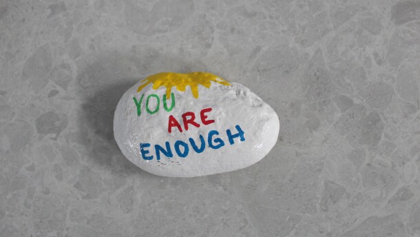 As domestic violence surges across Colorado, a painted rock at PorchLight Family Justice Center in Lakewood offers a reminder to survivors: “You Are Enough.”