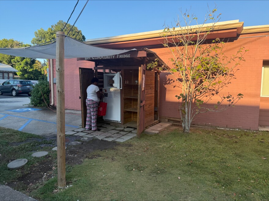 A Baton Rouge woman fills her reusable bag with food from a 24-hour community fridge, operated by Red Shoes, a non-profit organization. The fridge is open 24 hours to anyone in the community who needs food. Volunteers and businesses help keep the fridge stocked up with frozen and grab-and-go meals.
