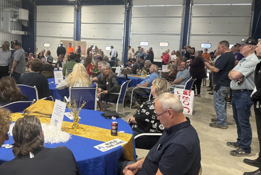 People stand and sit at tables during a "Build the Line" rally in Fairbanks June 3, 2026.