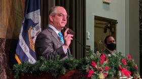 Louisiana Gov. John Bel Edwards holds up his mask as he addresses members of the press. Dec. 31, 2020.