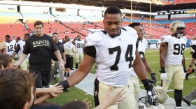 FILE - New Orleans Saints defensive end Glenn Foster Jr. (74) greets fans after practice before an NFL preseason football game against the Miami Dolphins, Thursday, Aug. 29, 2013, in Miami Gardens, Fla. (AP Photo/Wilfredo Lee, File)