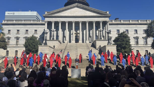 Red and blue silhouettes representing the 40 women and men who died from domestic violence are displayed during the 2026 Silent Witness Ceremony on the Statehouse grounds in Columbia.