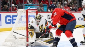 Washington Capitals center Nic Dowd (26) tries to get the puck past Vegas Golden Knights goaltender Akira Schmid (40) during the first period of an NHL hockey game, Friday, Feb. 27, 2026, in Washington. (AP Photo/Nick Wass)