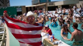 A fan cheers next to a pool at Circa Resort & Casino in Las Vegas while watching a live broadcast of a World Cup Group D soccer match between the United States and Australia, Friday, June 19, 2026. (AP Photo/John Locher)