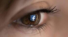 An illustration picture taken on March 22, 2018 in Paris shows a close-up of the Facebook logo in the eye of an AFP staff member posing while she looks at a flipped logo of Facebook. (CHRISTOPHE SIMON/AFP via Getty Images)