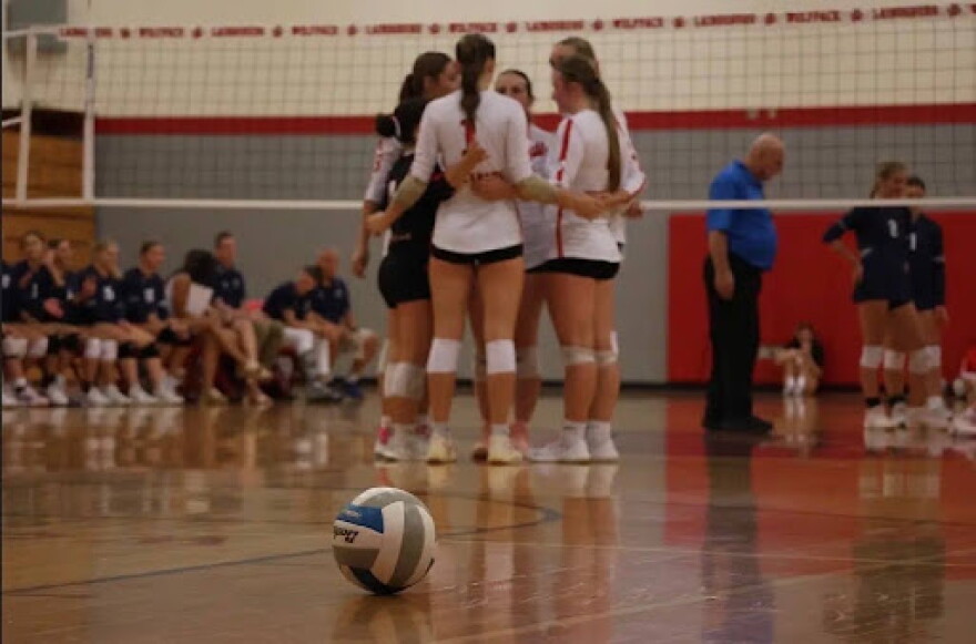 Kendall Michels and her team huddle before resuming play after a timeout.