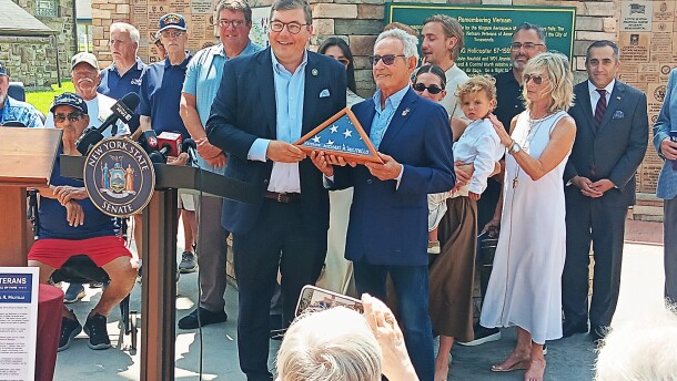 With family, friends and fellow veterans standing behind him, Michael Militello accepted a flag from State Senator Jeremy Zellner which flew over the State Capitol. Militello was honored in a July 1, 2026 ceremony in Tonawanda for his recent induction into the New York State Veterans Hall of Fame.