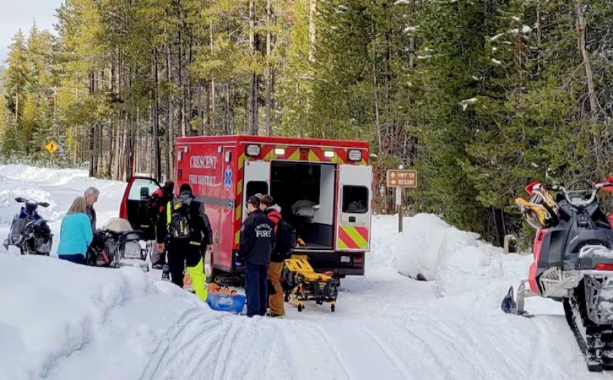 First responders load Erik Kerr into an ambulance on a snowy road.