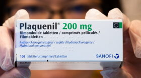 Illustration picture shows a pharmacist holding a box of Plaquenil.