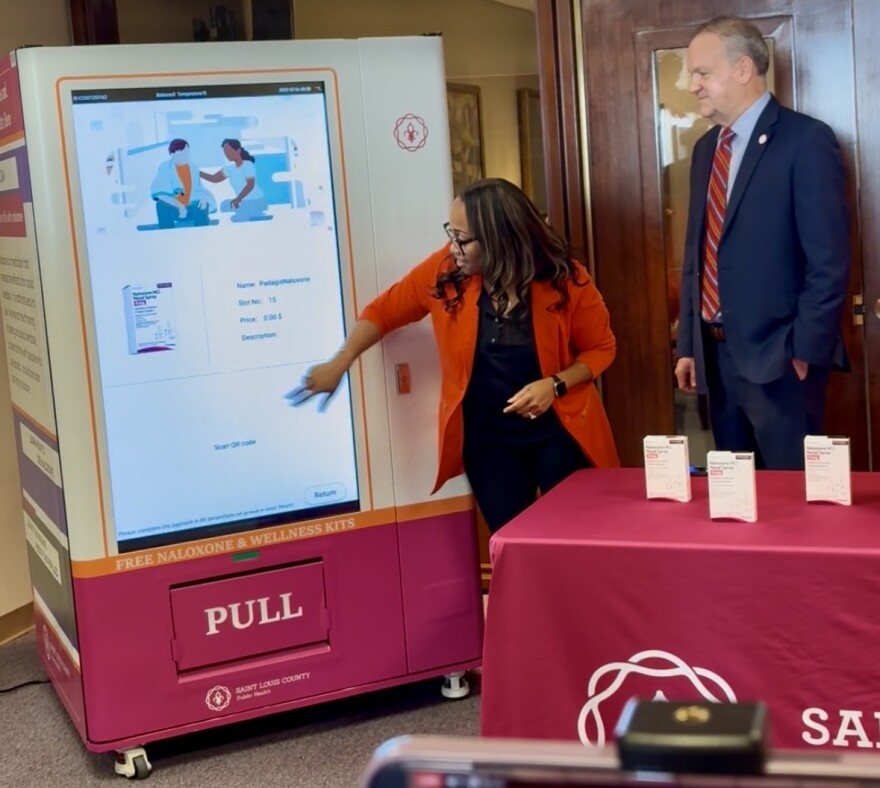 St. Louis County Health Director Kanika Cunningham and County Executive Sam Page demonstrate how to use a touch-screen naloxone "vending machine" at the county government headquarters in Clayton. 
