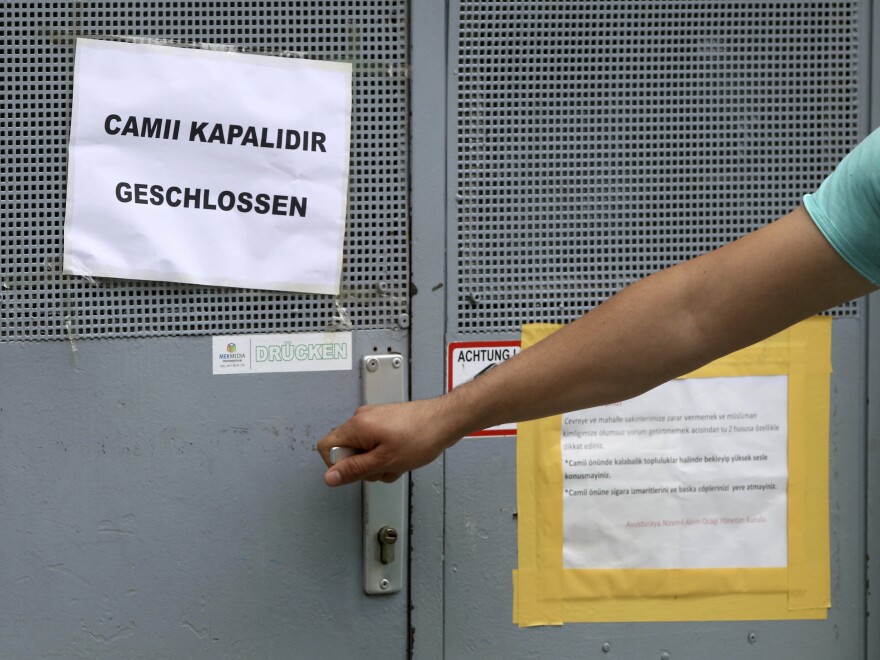 A person tries to open the door of a closed mosque in Vienna. The Austrian government said it's closing seven mosques as part of a crackdown on foreign financing of religious groups.