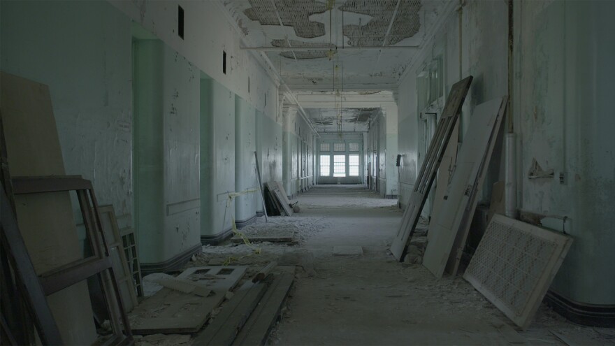 Abandoned, dusty hallway with window frames, doors etc. leaning against walls