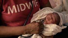 Midwife Marsha Jackson holds Zohra Marie Weeks after her delivery. Jackson stayed for hours after the birth to monitor mother Tonithia Reid and the baby and make sure they were healthy.