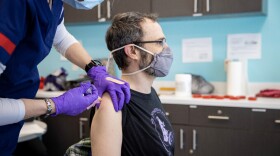 A person receives a COVID-19 vaccination at the Ball State University clinic location, operated by the Delaware County Health Department.