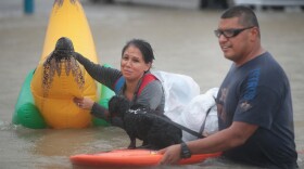 People make their way out of a flooded neighborhood in Houston on Monday. Many people are turning to social media for help.