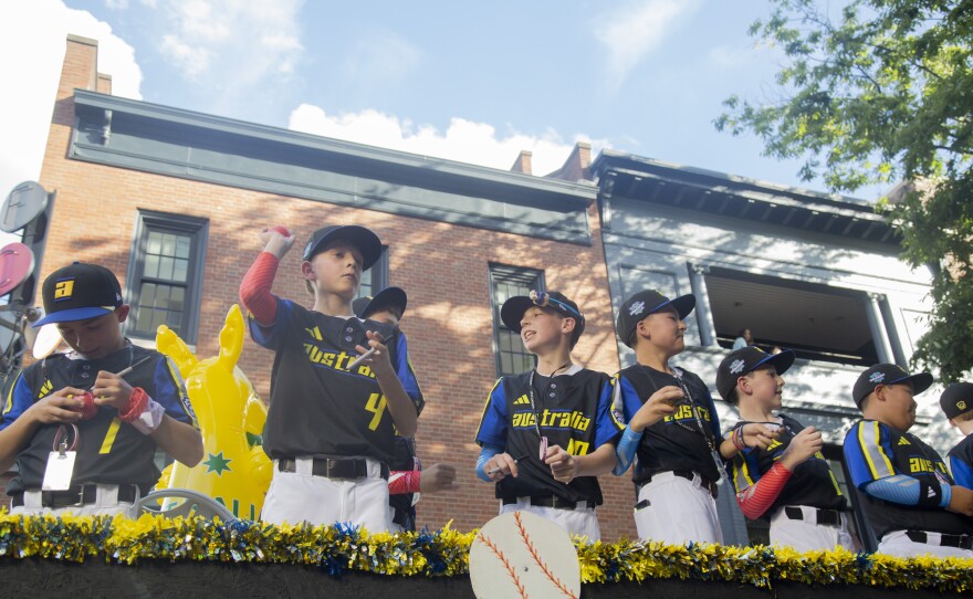 The team from Australia signs baseballs during the Little League World Series parade.