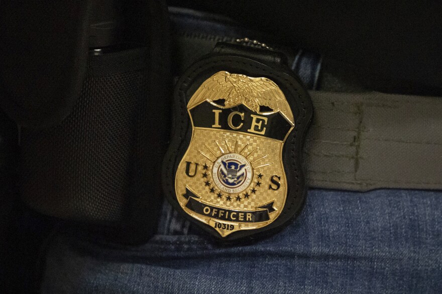 FILE - A federal agent wears an Immigration and Customs Enforcement badge in New York, June 10, 2025.