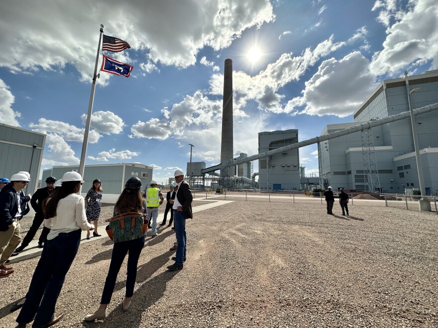 People standing in front of a coal plant, north of Gillette, on a sunny day.