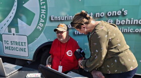 Melissa Kilway, a nursing assistant at Traverse Health Clinic, takes patient Arthur Anderson's blood pressure outside TC Street Medicine's Mobile Medical Unit.