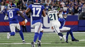 Seattle Seahawks cornerback Devon Witherspoon (21) gets by New York Giants quarterback Daniel Jones (8), wide receiver Parris Campbell (0) and wide receiver Wan'Dale Robinson (17) after intercepting a pass to run it back for a touchdown during the third quarter of an NFL football game, Monday, Oct. 2, 2023, in East Rutherford, N.J. (AP Photo/Adam Hunger)