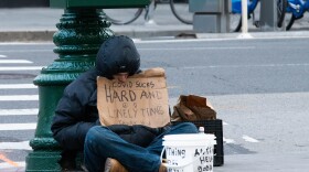 A homeless man sits on a New York City street corner during COVID-19 quarantine.