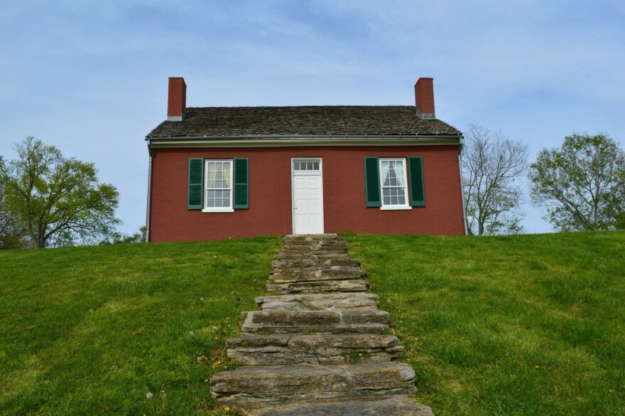 small red house atop a hillside with stone steps