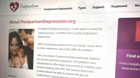 closeup of a webpage with text on postpartum depression and a photo showing a mom, dad and baby 