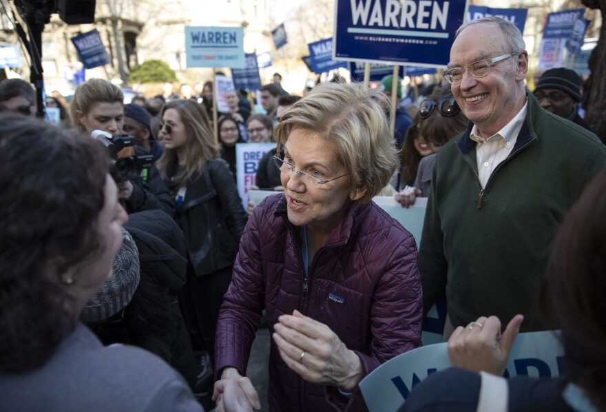 Sen. Elizabeth Warren and her husband, Bruce Mann, greet supporters on their way to vote in Cambridge, Mass.